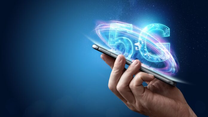 5GHandheld A stylized image of a hand holding a cell phone with the text '5G' written behind it