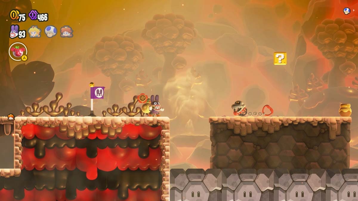 A fiery landscape in a Super Mario Bros. game, with a character about to jump over a lava pit