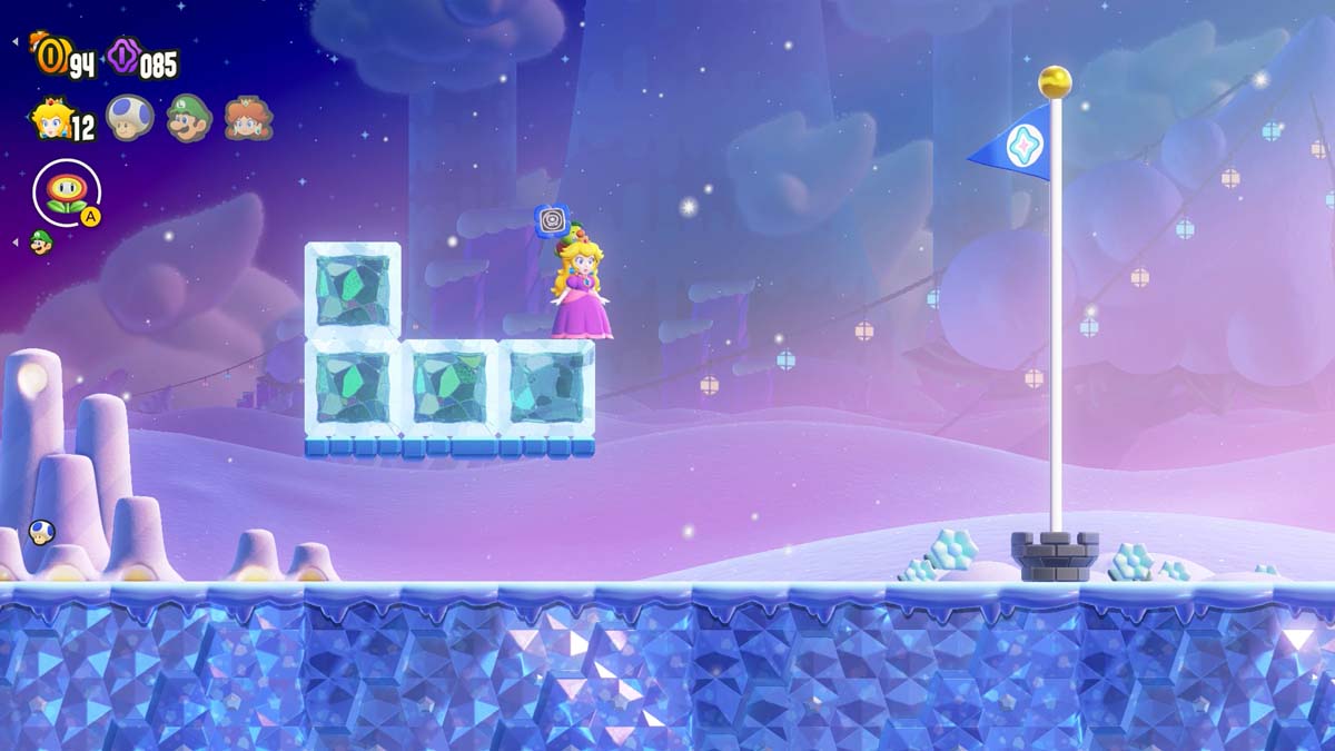 Princess Peach completes a level, poised on a block of ice with a starry night sky above and the finish line flag in sight